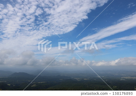 A breathtaking panoramic view of mountains under a clear blue sky and clouds. 138176893