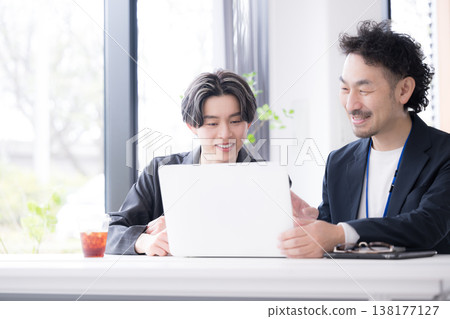A refreshing image of new employees, such as recent graduates, being encouraged by their superiors during meetings at work; on-the-job training (OJT) by senior colleagues. A refreshing image of new employees, such as recent graduates, being encouraged by their superiors during meetings at work; on-the-job training (OJT) by senior colleagues. 138177127