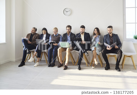 Business candidates waiting for job interview on chairs in bright modern office Business candidates waiting for job interview on chairs in bright modern office 138177205