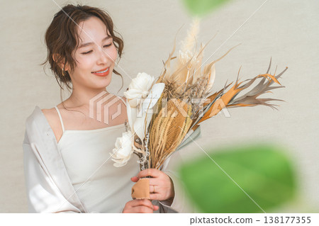 時尚女模特兒手捧花袋和花束。 時尚女模特兒手捧花袋和花束。 138177355