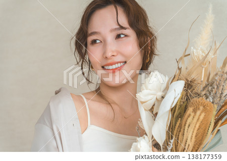 時尚女模特兒手捧花袋和花束。 時尚女模特兒手捧花袋和花束。 138177359