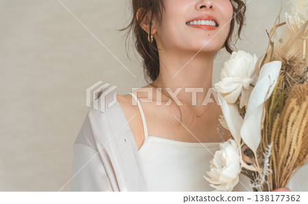時尚女模特兒手捧花袋和花束。 時尚女模特兒手捧花袋和花束。 138177362