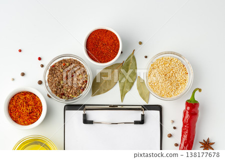 Spices and herbs arranged on a table with a clipboard for cooking ideas Spices and herbs arranged on a table with a clipboard for cooking ideas 138177678