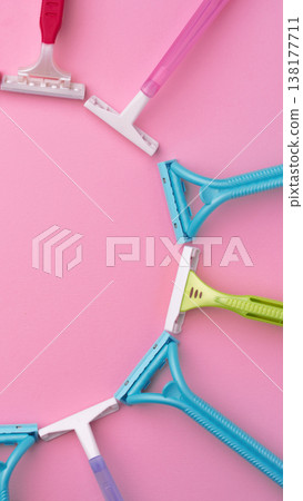 Different razors arranged in a circle on a pink background with no clear pattern or design 138177711