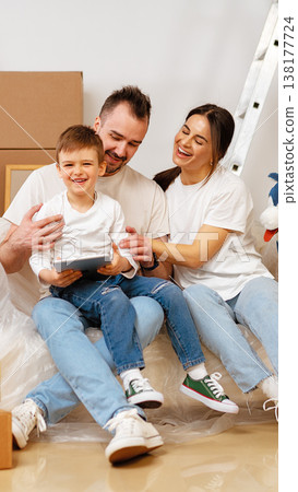 Family enjoys time together while unpacking boxes at home in the living room 138177724