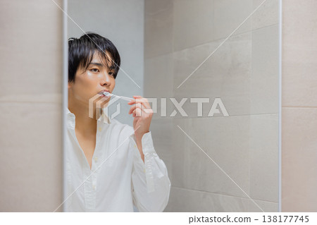 man brushing teeth in bathroom 138177745