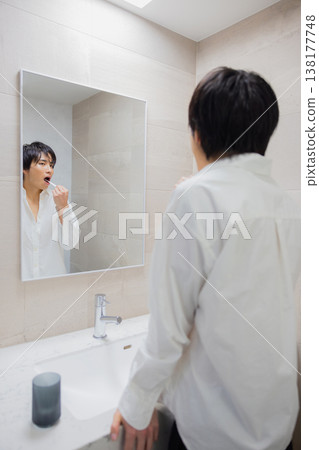 man brushing teeth in bathroom man brushing teeth in bathroom 138177748