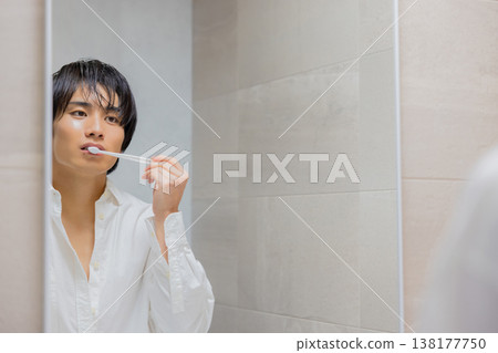 man brushing teeth in bathroom man brushing teeth in bathroom 138177750