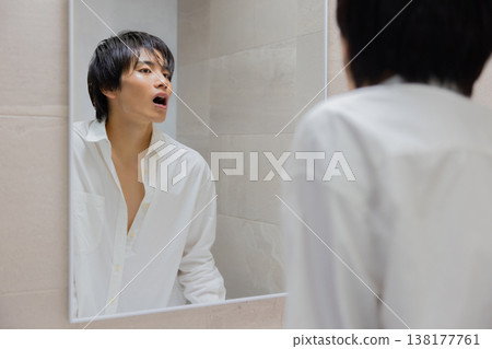 man brushing teeth in bathroom 138177761