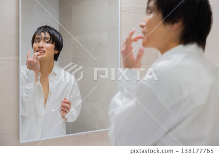 man brushing teeth in bathroom man brushing teeth in bathroom 138177765