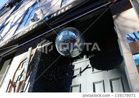街角景色，建築物入口上方懸掛著一個鏡面球，光線在其上美麗地反射。 138178071