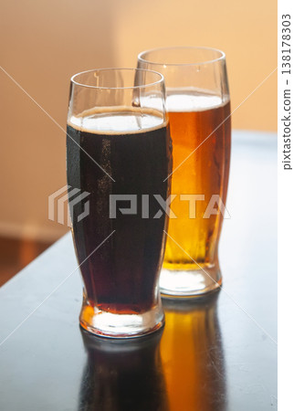 Two glasses of light and dark beer on table 138178303