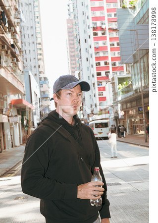 Caucasian Man Holding Bottle on Hong Kong City Street Caucasian Man Holding Bottle on Hong Kong City Street 138178998