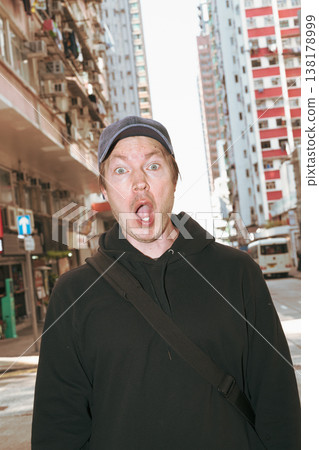 Shocked Caucasian Man on Hong Kong City Street with Skyscrapers Shocked Caucasian Man on Hong Kong City Street with Skyscrapers 138178999