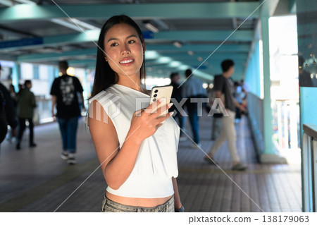 Thai Woman Using Smartphone on Hong Kong Pedestrian Walkway Thai Woman Using Smartphone on Hong Kong Pedestrian Walkway 138179063