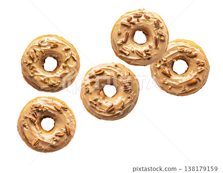Top view of multiple maple glazed donuts with chopped pecans, isolated on white background, concept of sweet pastry pattern Top view of multiple maple glazed donuts with chopped pecans, isolated on white background, concept of sweet pastry pattern 138179159