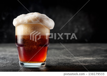 A glass of red beer with rich foam shown on a dark background, concept of refreshment and craft brewing A glass of red beer with rich foam shown on a dark background, concept of refreshment and craft brewing 138179533