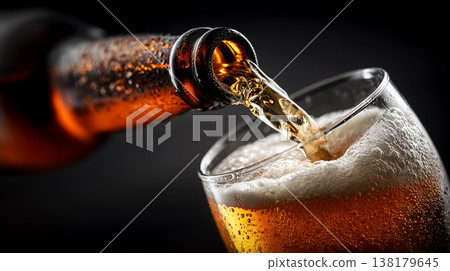 Fizzy dark stout beer being poured into chilled glass on warm brown background, concept of refreshment and taste Fizzy dark stout beer being poured into chilled glass on warm brown background, concept of refreshment and taste 138179645
