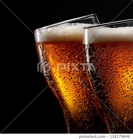 Closeup of two sparkling beer glasses toasting, on dark background, symbolizing celebration spirit Closeup of two sparkling beer glasses toasting, on dark background, symbolizing celebration spirit 138179646