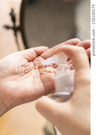 A woman's hands applying makeup. A woman's hands applying makeup. 138180574