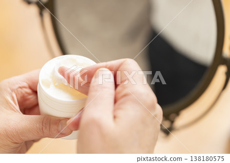 A woman's hands applying makeup. A woman's hands applying makeup. 138180575