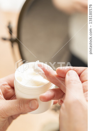 A woman's hands applying makeup. A woman's hands applying makeup. 138180576