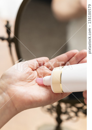 A woman's hands applying makeup. A woman's hands applying makeup. 138180579