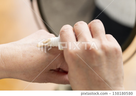 A woman's hands applying makeup. A woman's hands applying makeup. 138180580
