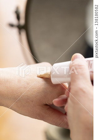 A woman's hands applying makeup. A woman's hands applying makeup. 138180582
