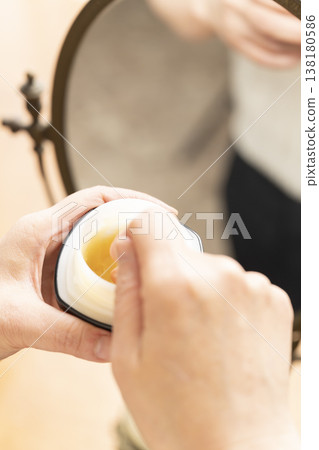 A woman's hands applying makeup. A woman's hands applying makeup. 138180586