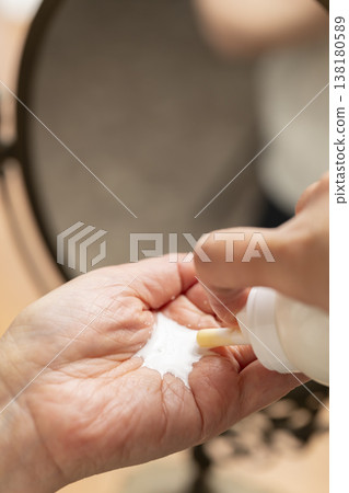 A woman's hands applying makeup. A woman's hands applying makeup. 138180589