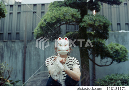 A person in a fox mask who makes water burst in their hands A person in a fox mask who makes water burst in their hands 138181171
