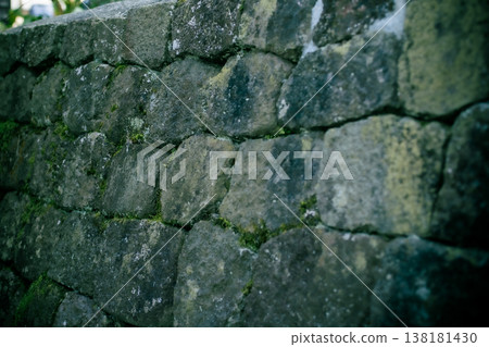 Traces of time etched into the moss-covered stone wall Traces of time etched into the moss-covered stone wall 138181430