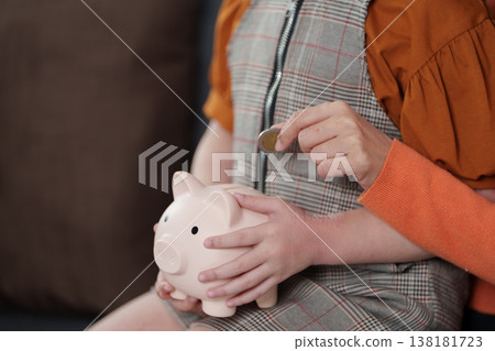 Mother teaching child financial savings with piggy banks 138181723