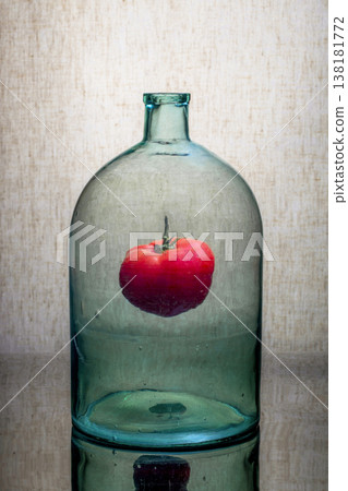 Still life with a glass jar and a tomato inside 138181772