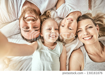 Happy, love and portrait of family on a bed for bonding and relaxing together at modern home. Happiness, smile and top view of girl children lying with parents from Australia in bedroom at house. Happy, love and portrait of family on a bed for bonding and relaxing together at modern home. Happiness, smile and top view of girl children lying with parents from Australia in bedroom at house. 138181876