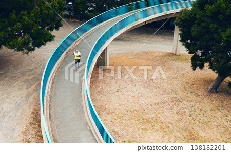 Above, man and running on bridge in nature, countryside or outdoor in environment with path in woods. Athlete, run or walking on road for cardio, fitness or exercise in forest with eco infrastructure 138182201