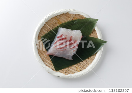 天然鯛魚刺身盛放在竹籃中,以白色為背景。 天然鯛魚刺身盛放在竹籃中,以白色為背景。 138182207