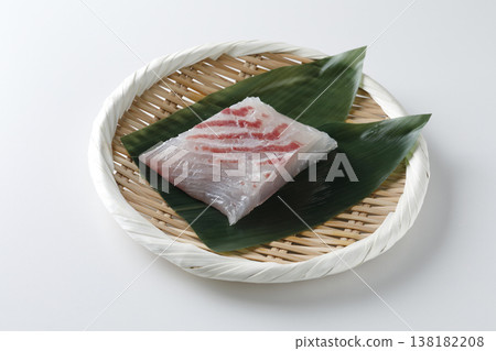 Natural sea bream sashimi served in a bamboo basket against a white background. Natural sea bream sashimi served in a bamboo basket against a white background. 138182208