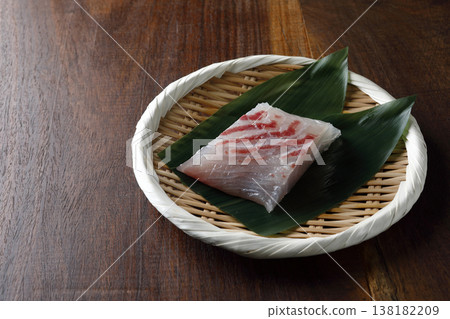 天然鯛魚刺身，盛裝放在木紋背景的竹籃中。 138182209