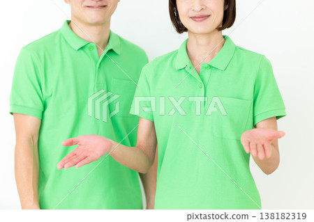 A middle-aged care worker wearing a green polo shirt. 138182319