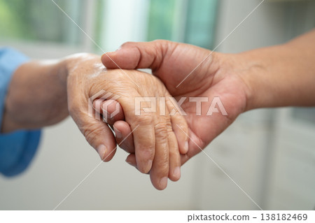 Caregiver holding hands Asian elderly woman patient, help and care in hospital. Caregiver holding hands Asian elderly woman patient, help and care in hospital. 138182469