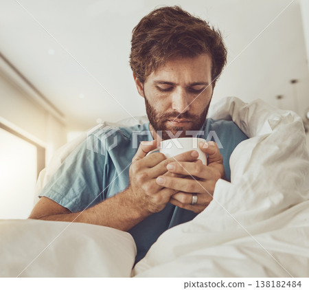Tea, sick and a man with a blanket on a sofa in the living room of his home for recovery from cold or flu. Coffee, healthcare or lemon and ginger drink in a cup with a young person feeling unwell Tea, sick and a man with a blanket on a sofa in the living room of his home for recovery from cold or flu. Coffee, healthcare or lemon and ginger drink in a cup with a young person feeling unwell 138182484