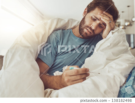 Thermometer, stress and sick man on a sofa with headache, fever or influenza crisis in his home. Anxiety, high temperature and male person with vertigo, risk or fear of covid infection in living room Thermometer, stress and sick man on a sofa with headache, fever or influenza crisis in his home. Anxiety, high temperature and male person with vertigo, risk or fear of covid infection in living room 138182498