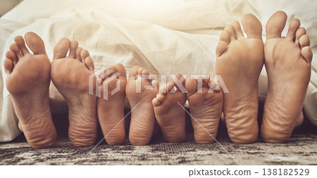 Feet, love and family in bed together to relax on a weekend morning in their home with flare. Mother, father and children with blankets sleeping in the bedroom to rest while dreaming closeup Feet, love and family in bed together to relax on a weekend morning in their home with flare. Mother, father and children with blankets sleeping in the bedroom to rest while dreaming closeup 138182529
