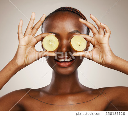 Kiwi, wellness and a black woman on a studio background for skincare, dermatology and a glow. Nutrition, hands and an African person or model with fruit for health, diet food and an organic snack Kiwi, wellness and a black woman on a studio background for skincare, dermatology and a glow. Nutrition, hands and an African person or model with fruit for health, diet food and an organic snack 138183128