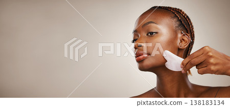 Skincare, black woman or gua sha on face for beauty, acne or blood circulation in studio on brown background. Cosmetic, person and facial product for lymphatic drainage, wellness and mock up for skin 138183134