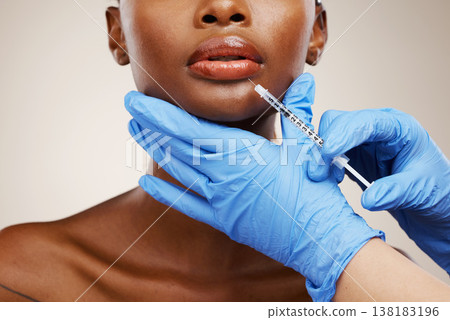 Closeup, black woman and needle with plastic surgery, healthcare and cosmetics on a white studio background. African person, girl and model with injection, hands and gloves with wellness and skincare Closeup, black woman and needle with plastic surgery, healthcare and cosmetics on a white studio background. African person, girl and model with injection, hands and gloves with wellness and skincare 138183196