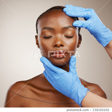 Portrait, hands and plastic surgeon with a black woman patient in studio on a gray background for cosmetic change. Face, beauty and transformation with a young model getting ready for derma treatment 138183202