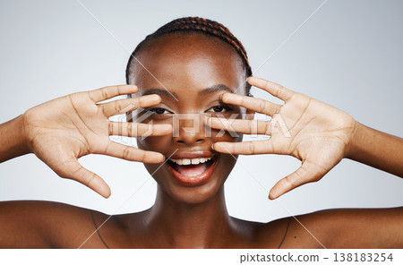 Wellness, hands and portrait of black woman for skincare, beauty reveal and excited on a studio background. Smile, young and African person with a gesture for clean facial skin or a dermatology glow Wellness, hands and portrait of black woman for skincare, beauty reveal and excited on a studio background. Smile, young and African person with a gesture for clean facial skin or a dermatology glow 138183254